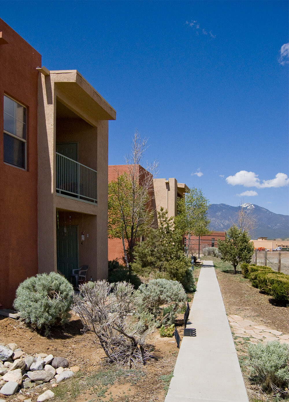 Front door and walkway at Tierra Montosa with snow-capped Taos Mountain down the path