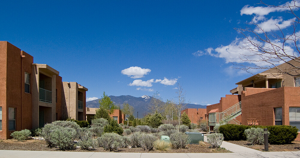 Wide view of Tierra Montosa homes in Taos with Taos Mountain rising between the buildings