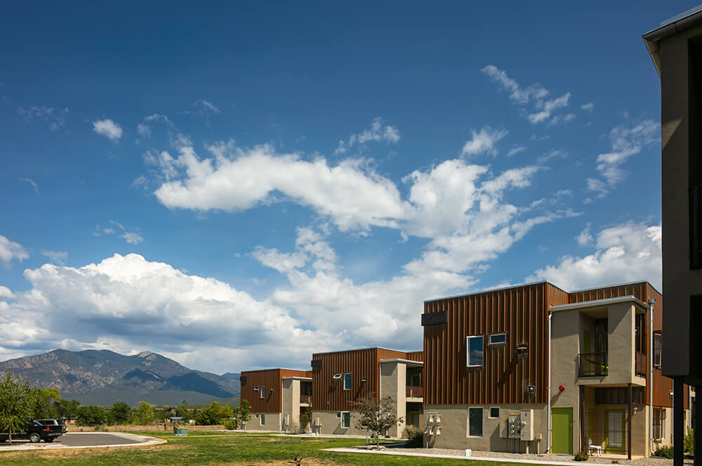 The newest Tierra Montosa homes with weathered-steel siding under a big summer sky, Taos NM