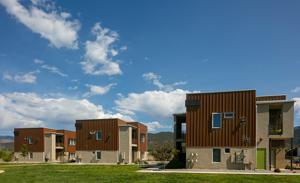Green lawn in front of the 2018 Tierra Montosa buildings with their rusted-steel and stucco facades