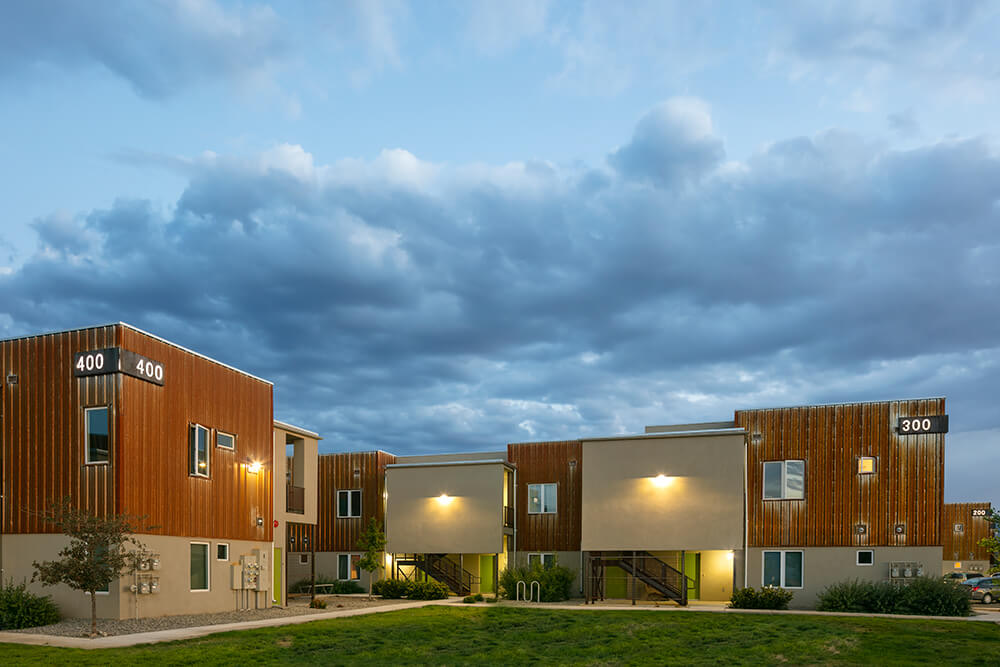 Tierra Montosa homes at dusk with entry lights glowing and green front doors, Taos NM